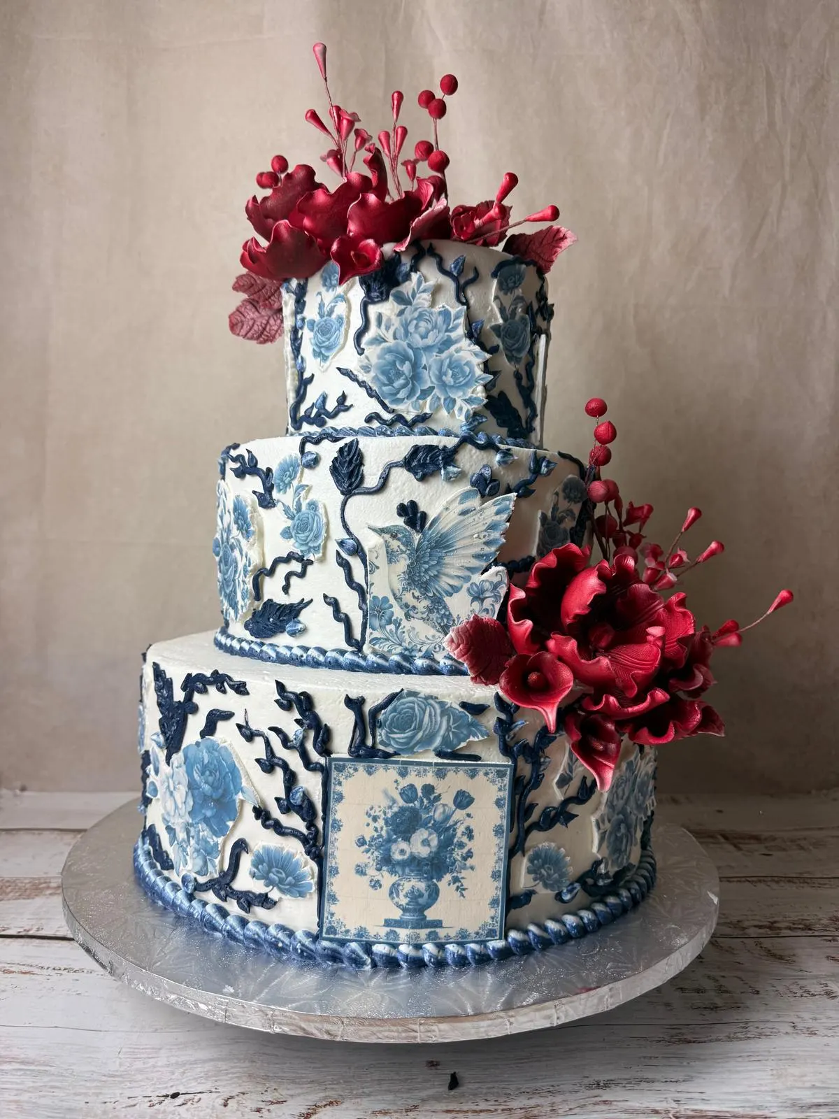 Three-tier blue and white porcelain-pattern cake with red sugar flowers